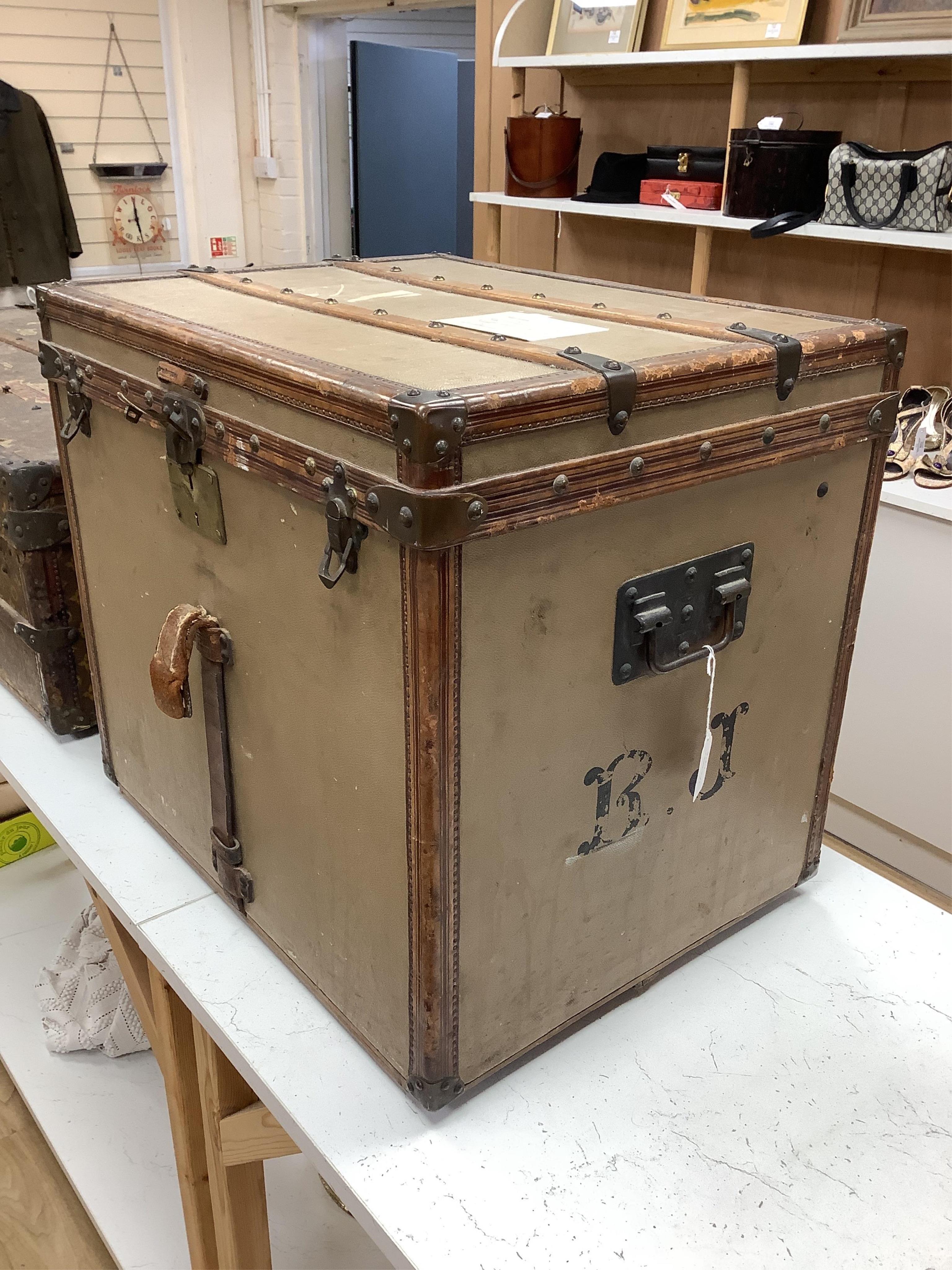 A vintage Louis Vuitton trunk, with brass and leather mounts and studded wooden slats, in plain beige canvas, with label for Paris and London, number 159008, 61cm wide, 48cm deep, 53cm high